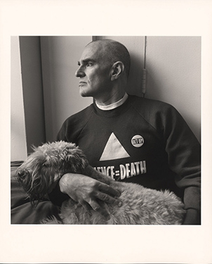 Waist length photo of a man with a dog looking out of a window