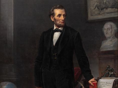 Man in a black suit with his hand clutching a book